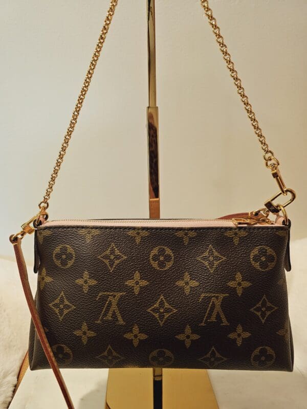 A brown and gold purse sitting on top of a table.