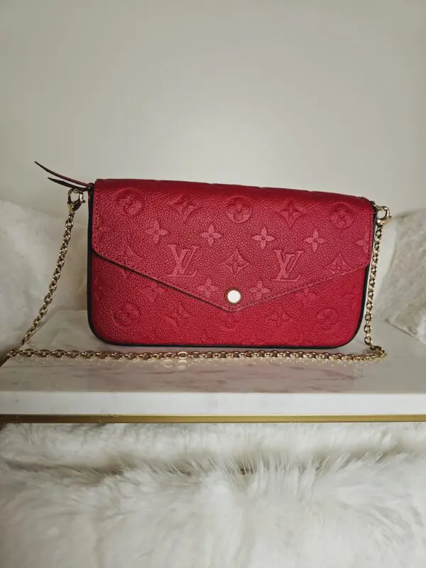 A red purse sitting on top of a white table.