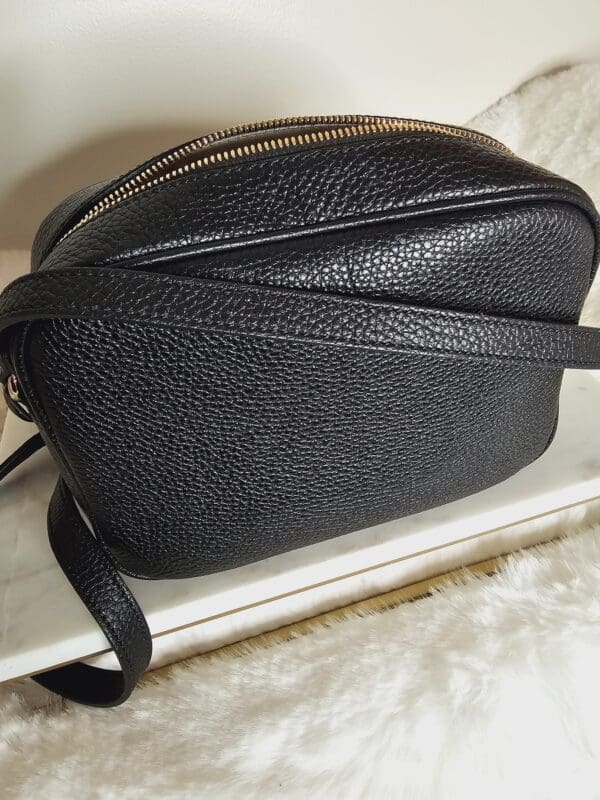 A black purse sitting on top of a white table.