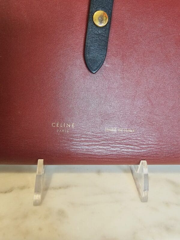 A red leather book with a black stone on top of it.