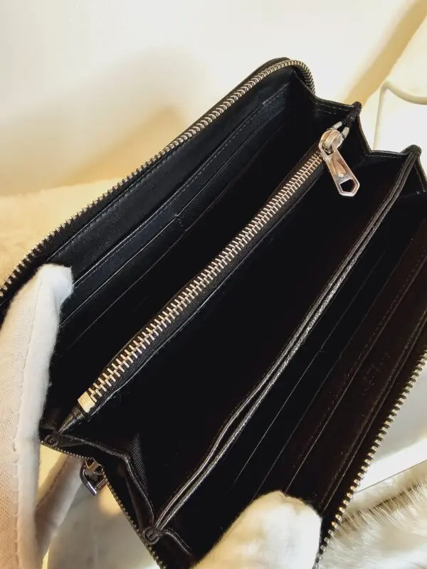 A black wallet is open and has two zippers.