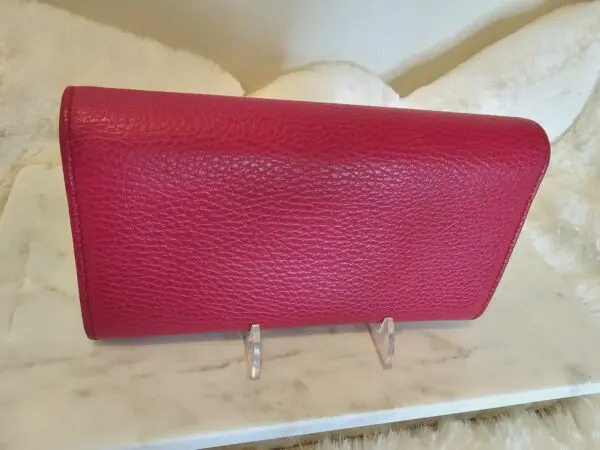 A red wallet sitting on top of a table.