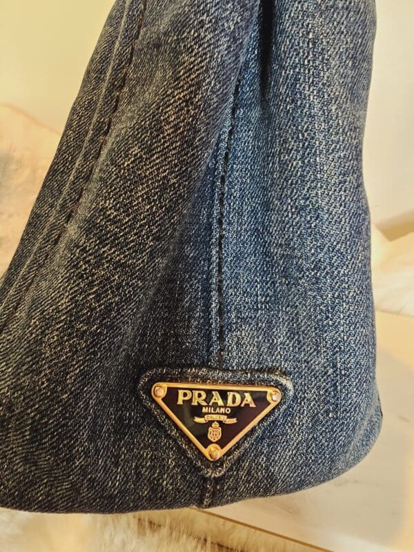 A close up of the prada patch on someone 's jeans