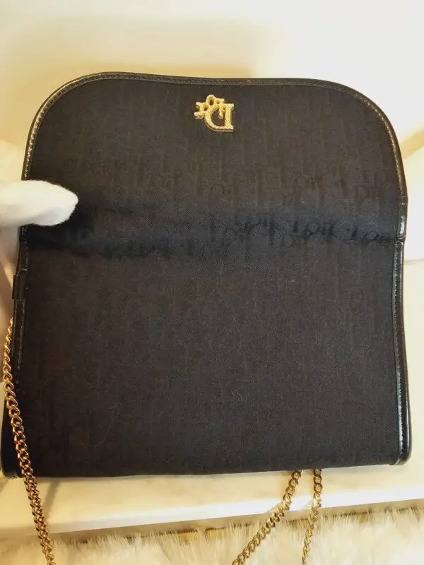 A black purse with gold chain and a little crown on it