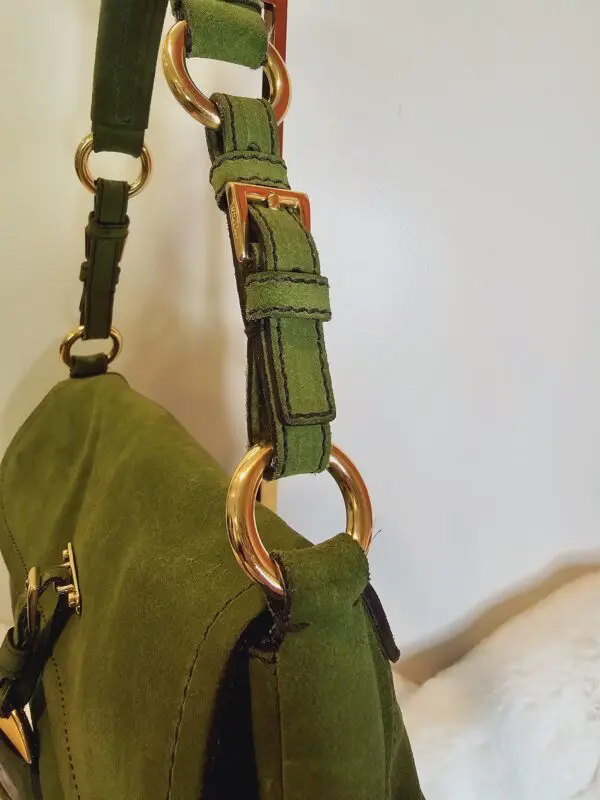 A green purse hanging on the wall