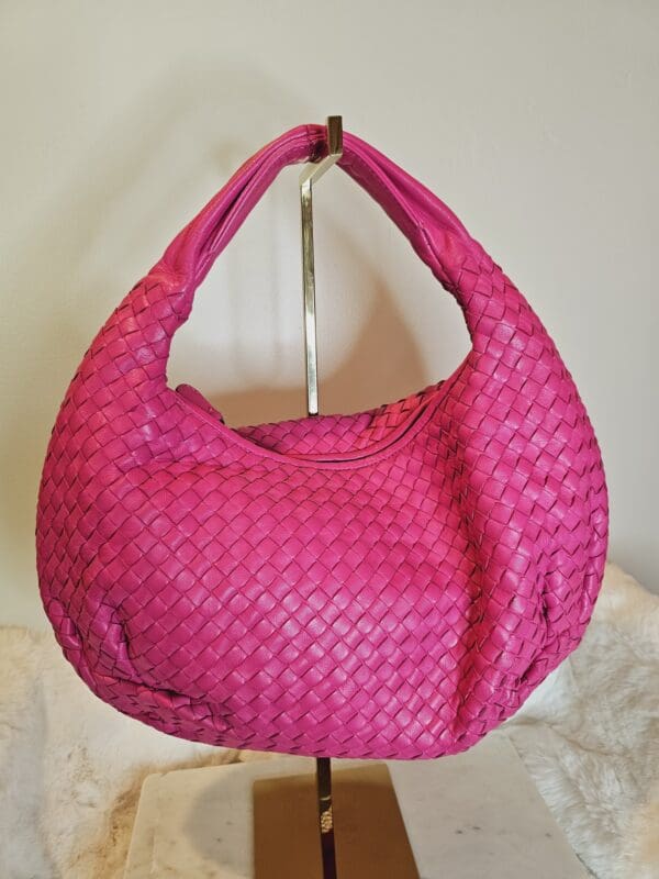 A pink purse hanging on the wall