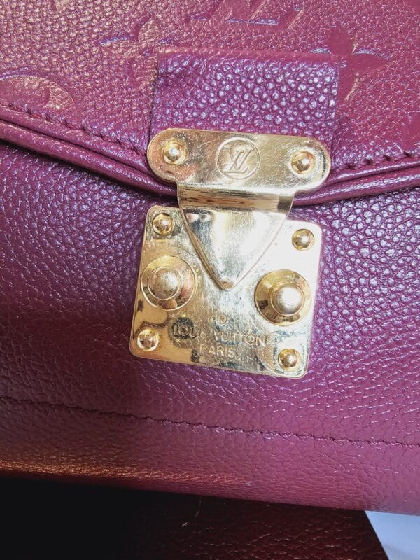 A close up of the lock on a purple purse