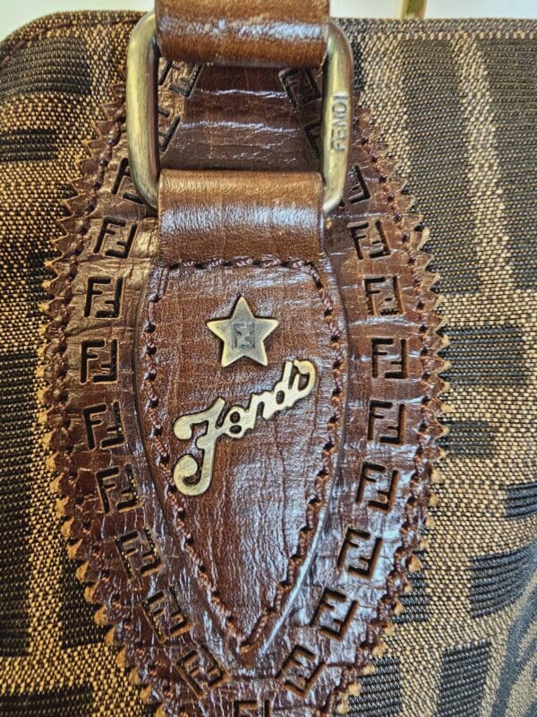 A close up of the leather belt with a star and name