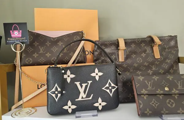 A table with several louis vuitton bags and purses.