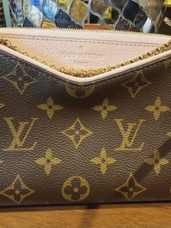 A close up of the front of a louis vuitton bag