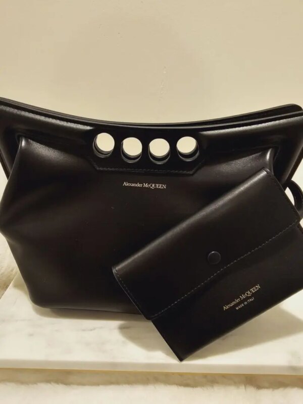 A black purse and wallet sitting on top of a table.