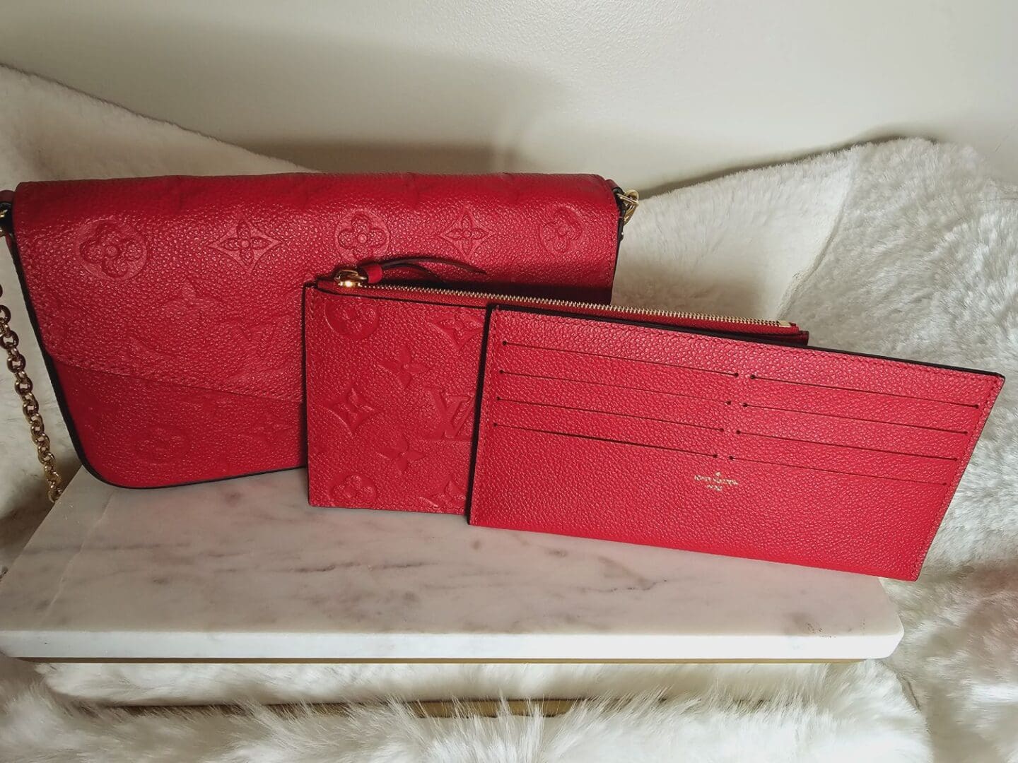 Three red wallets sitting on a table.