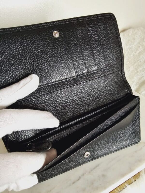 A person is holding onto the inside of a wallet.