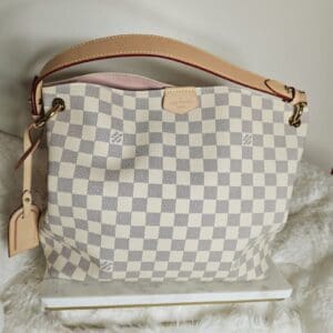 A white and gray checkered purse sitting on top of a table.