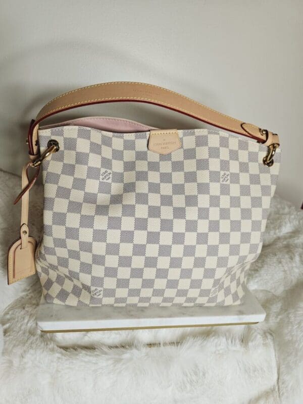 A white and gray checkered purse sitting on top of a table.