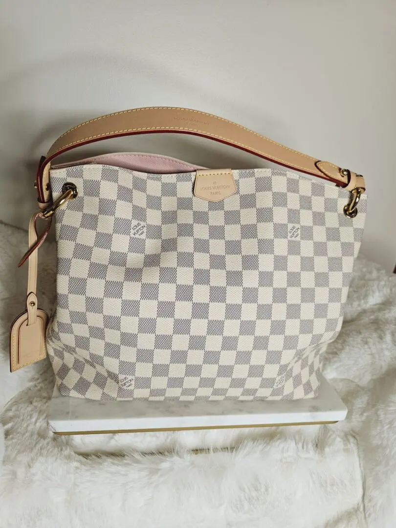 A white and gray checkered purse sitting on top of a table.