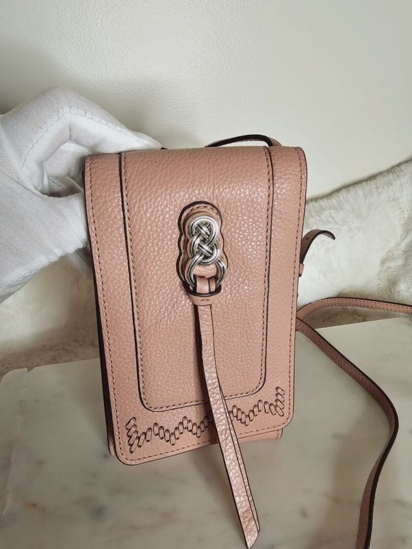 A pink purse sitting on top of a table.