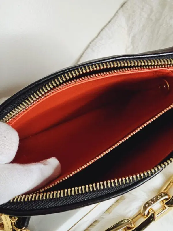 A person holding onto the inside of their purse