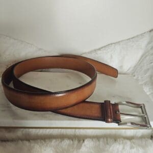 A brown belt sitting on top of a white box.