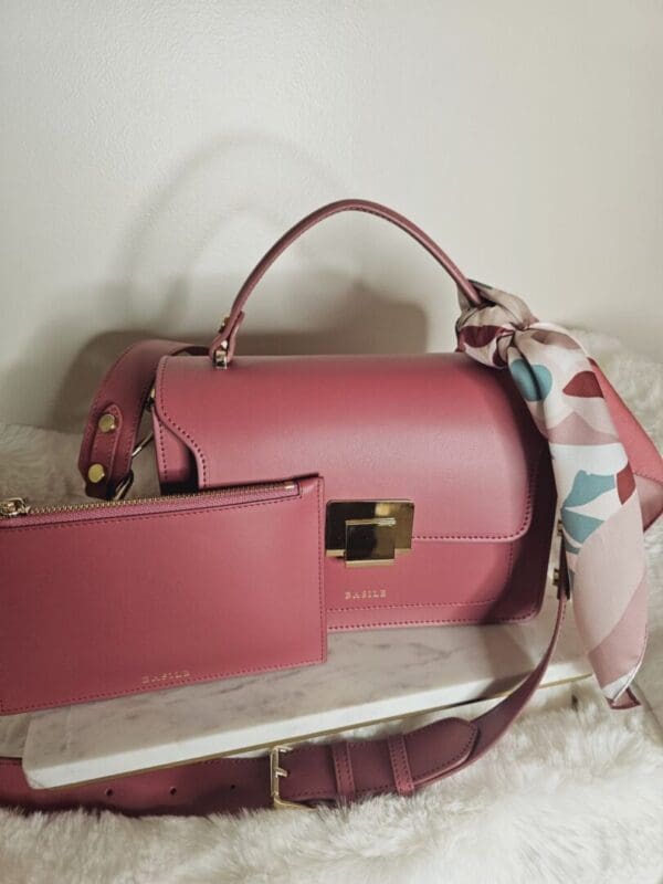 A pink purse and wallet sitting on top of a table.