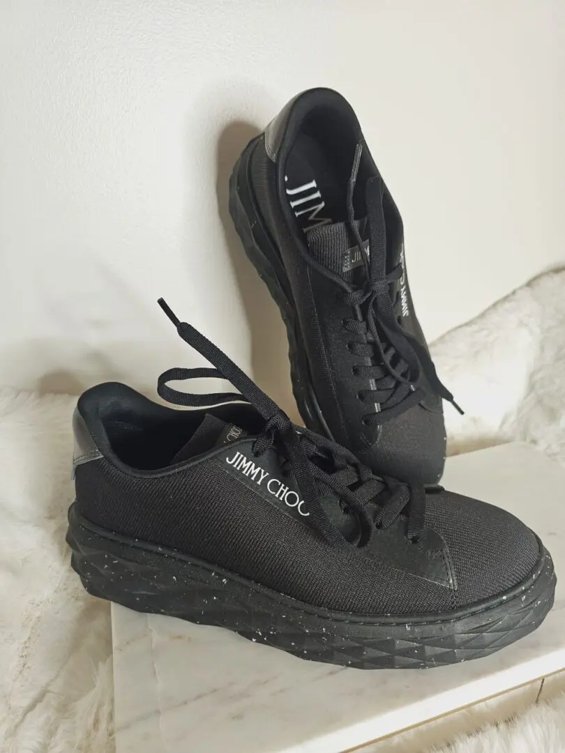 A pair of black shoes sitting on top of a white surface.