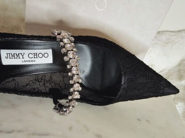 A pair of black shoes with a chain on the side.