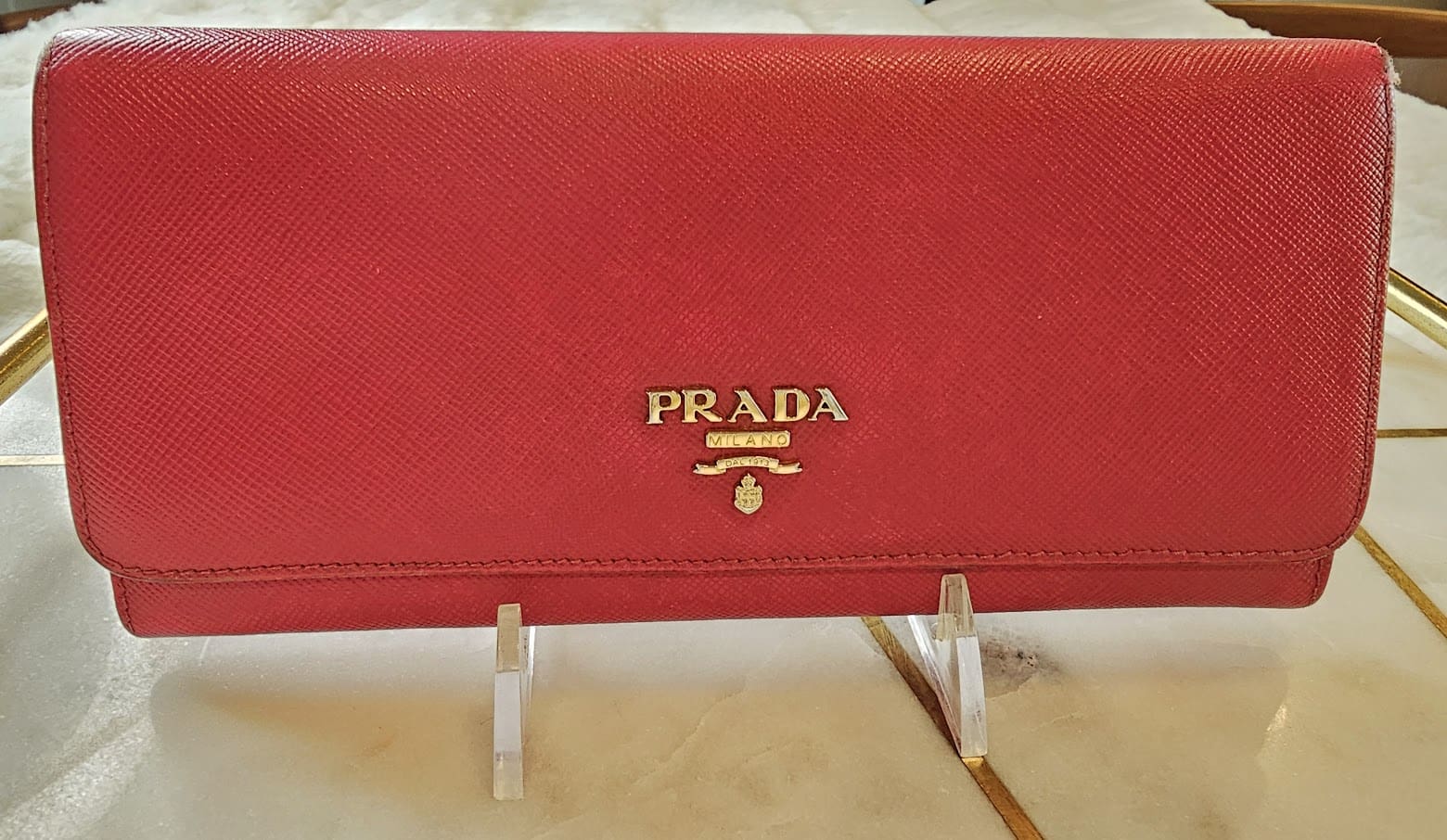 A red prada wallet sitting on top of a table.