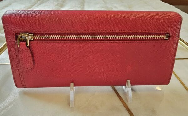 A red leather wallet sitting on top of a table.