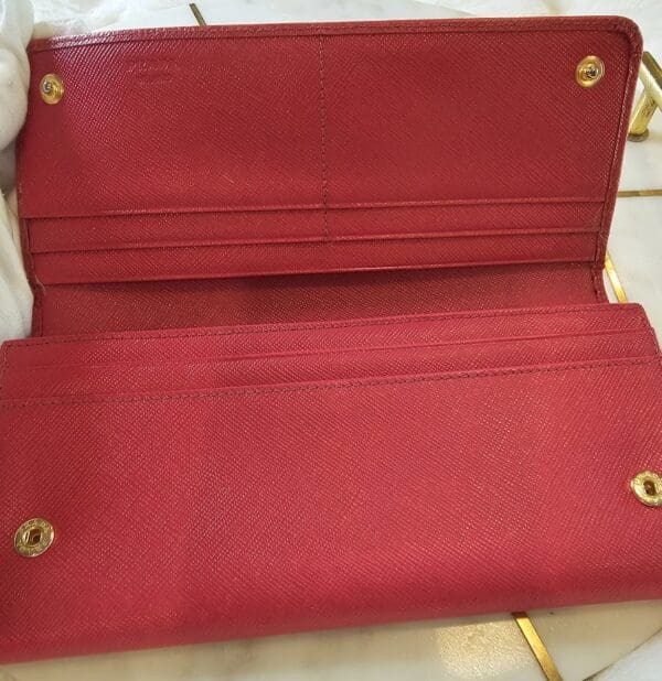 A red wallet sitting on top of the floor.