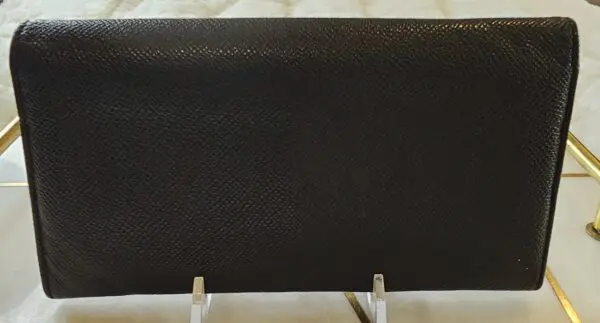 A black leather book cover sitting on top of a table.