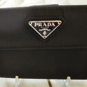 A black purse with a logo on it.