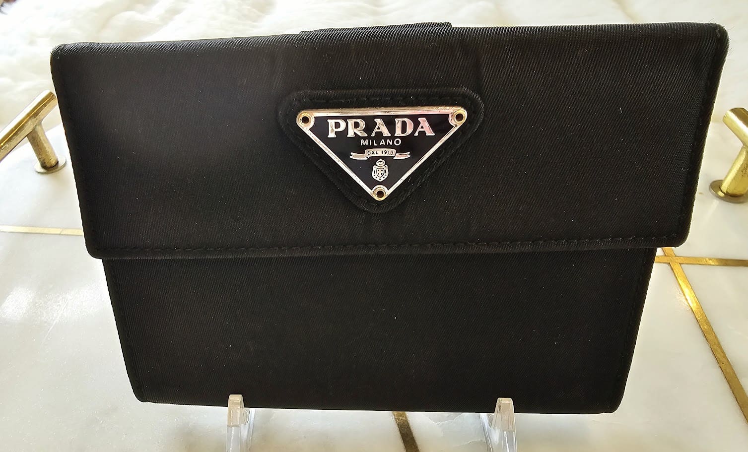 A black purse with a logo on it.