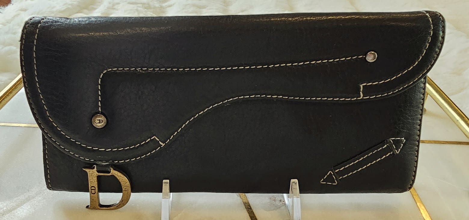 A black wallet with a string of gold thread.