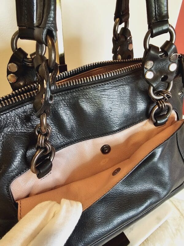 A black purse with some leather straps on it