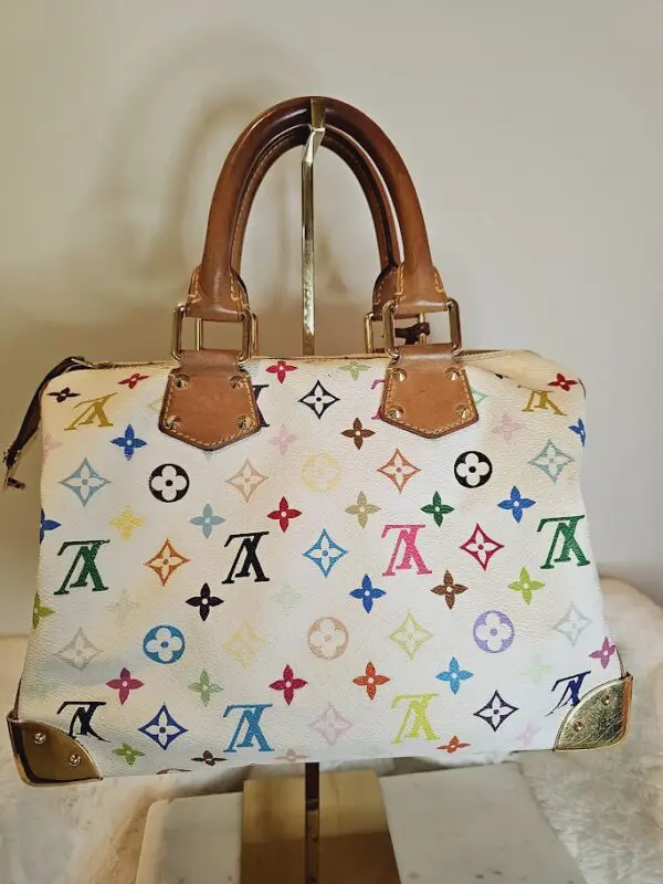 A white purse with multi colored stars on it.