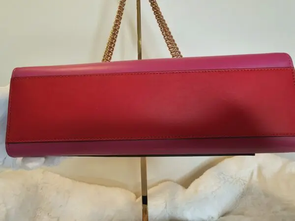 A red purse hanging on the wall