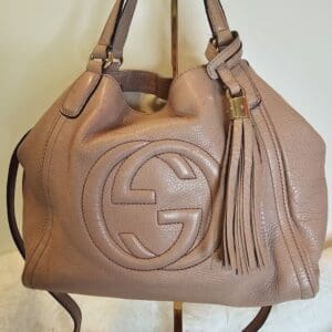 A tan purse sitting on top of a wooden table.