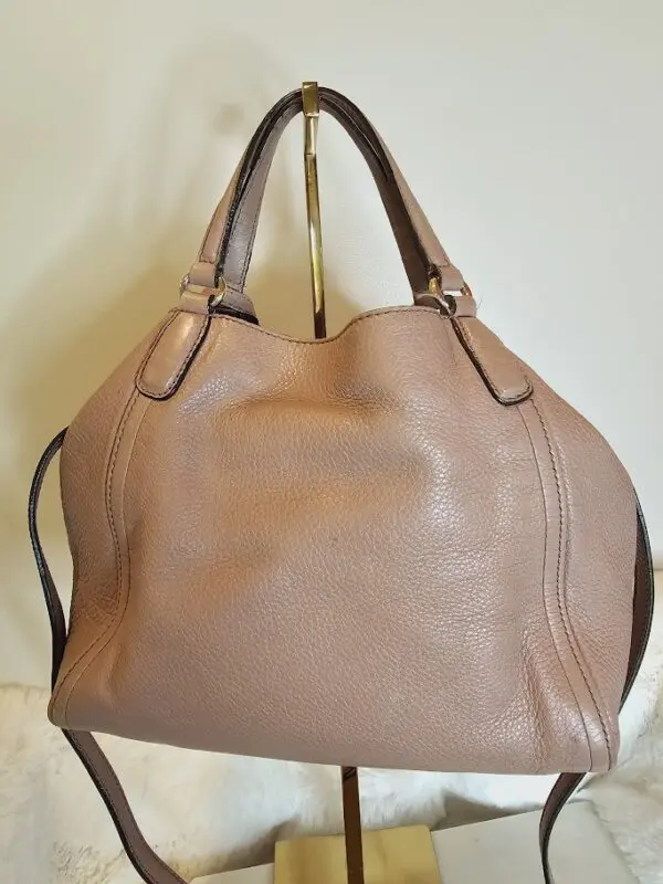 A brown purse hanging on the wall