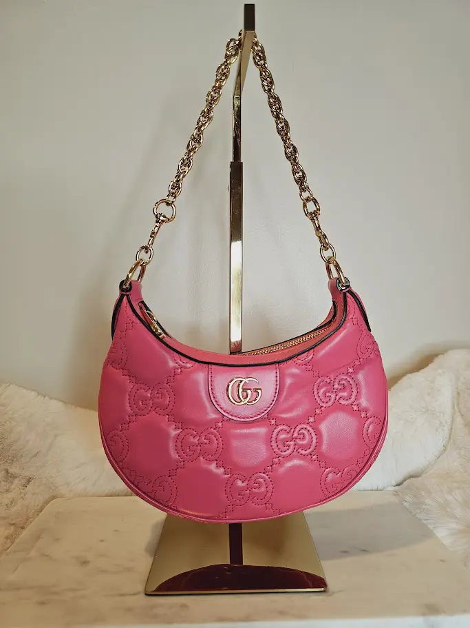 A pink purse hanging on the wall