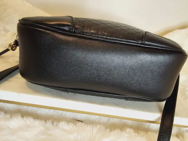 A black purse sitting on top of a white table.