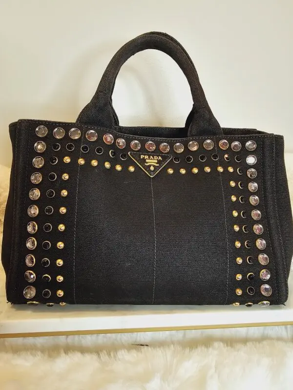 A black purse with gold and silver studs on it.