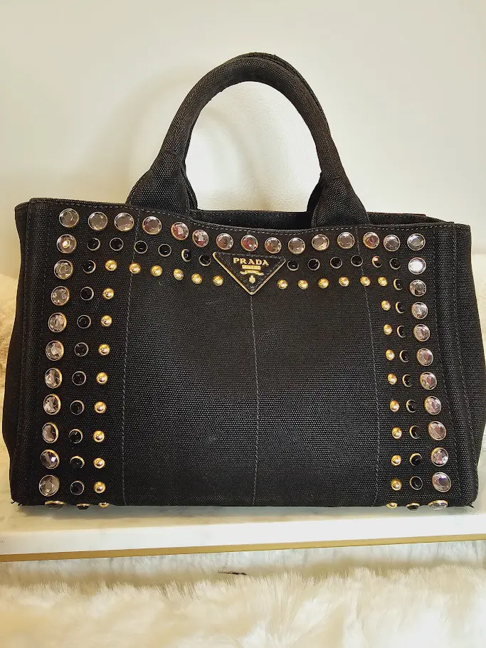 A black purse with gold and silver studs on it.