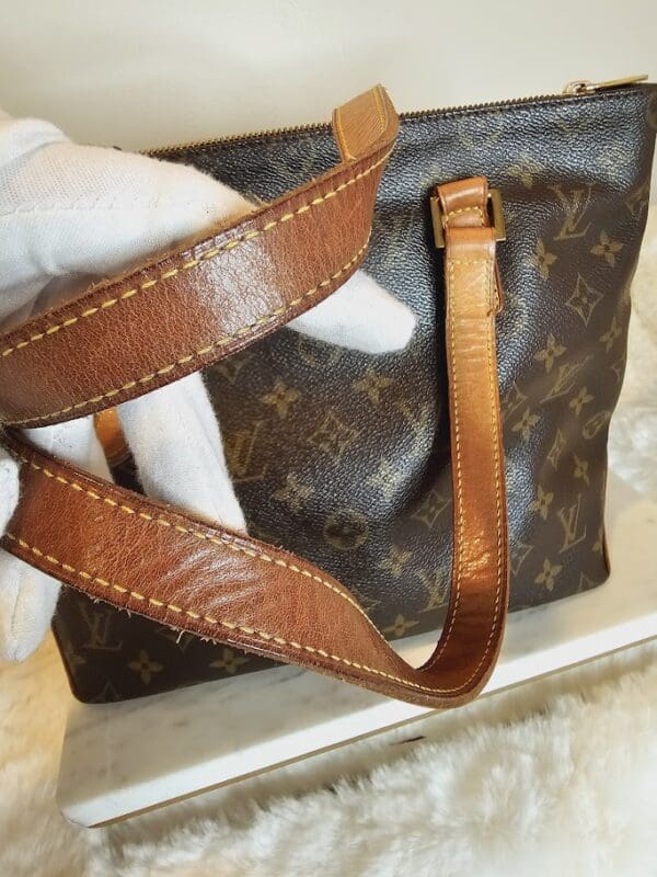 A person holding onto a brown and black bag