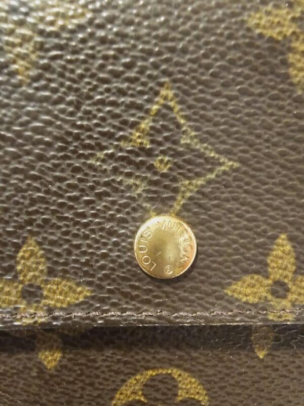 A coin is sitting on the side of a purse.