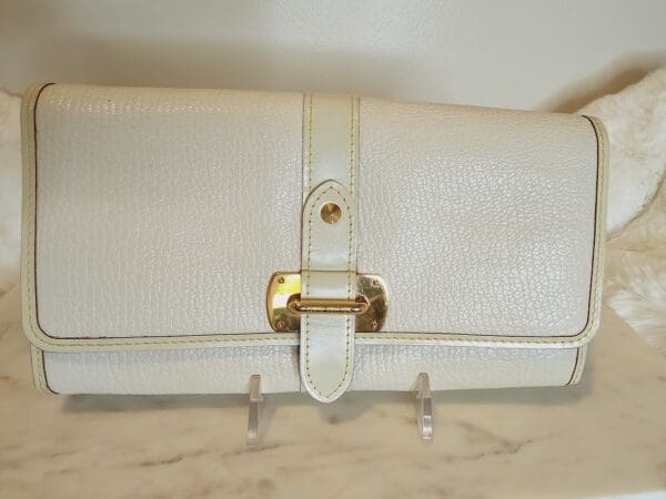 A white purse with gold accents on the side.