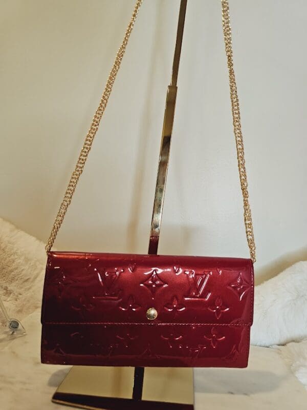 A red purse is hanging on the wall