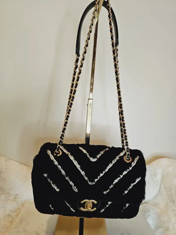 A black purse with white and silver design on it.