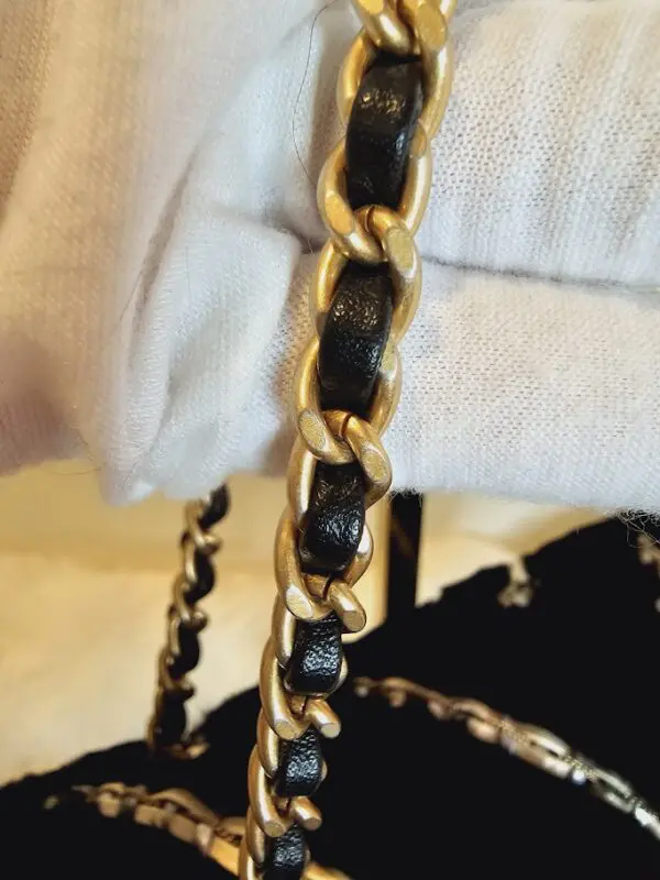 A close up of the chain on a purse