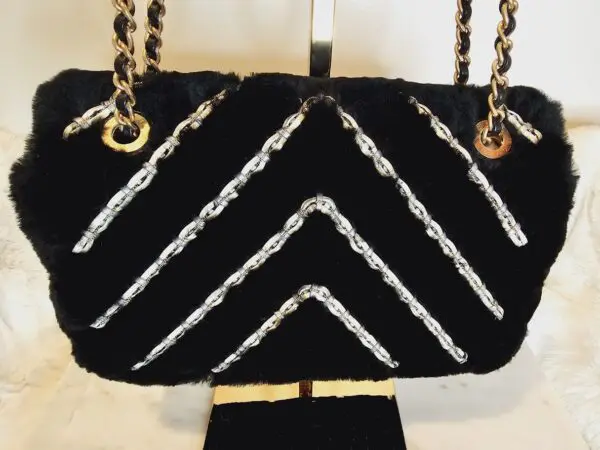 A black purse with white and gold trim.