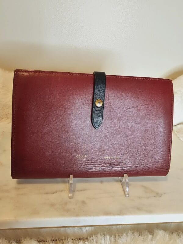 A red leather wallet sitting on top of a counter.